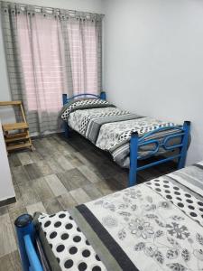 2 camas individuales en una habitación con ventana en Don Mateo - Casa de Campo en Salta