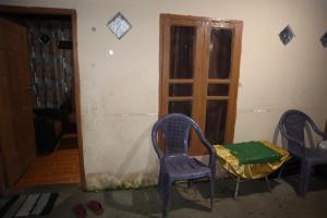 2 Stühle und ein Tisch in einem Zimmer mit Tür in der Unterkunft Homestay Kurnia 