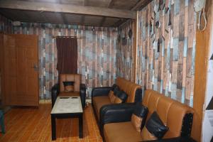 a living room with two leather couches and a table at Homestay Kurnia 