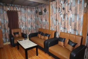 ein Wohnzimmer mit 2 Stühlen und einem Tisch in der Unterkunft Homestay Kurnia 