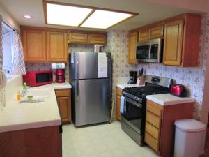 La cuisine est équipée d'un réfrigérateur en acier inoxydable et de placards en bois. dans l'établissement Slopeside Chalet, à Big Bear Lake