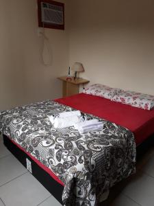 a bedroom with a bed with a black and white comforter at Apartamento residencial in Blumenau