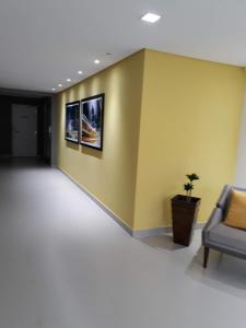 a waiting room with a couch and a yellow wall at Apartamento residencial in Blumenau
