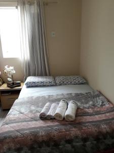 a bedroom with a bed with two towels on it at Apartamento residencial in Blumenau