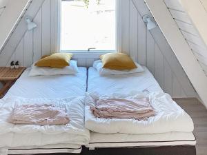 two beds in a room with a window at Holiday home Farsø XXIII in Farsø