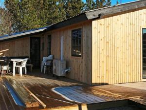 a wooden cabin with a table on a deck at Holiday home Hadsund CXLIII in Hadsund