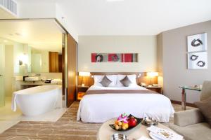 バンコクにあるセンタラ グランド アット セントラル プラザ ラープラオ バンコク（旧ソフィテル センタラ グランド バンコク）のベッドとバスタブ付きのホテルルームです。