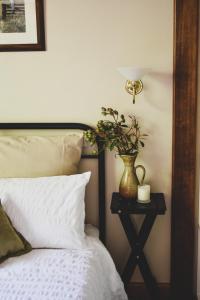 a bed with a table with a vase with a plant on it at Millers Nook - Central Charm in Albury