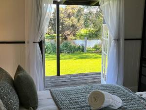 a bedroom with a bed with a view of a window at Secluded rural retreat in Southwest WA in Capel