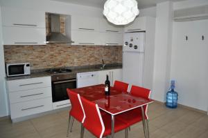 a kitchen with a red table and red chairs at Antalya belek green park golf apart ground floor 2 bedrooms close the beach park in Belek