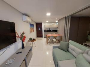 uma sala de estar com um sofá e uma sala de jantar em Solar Tambaú - Loft sun and sea - ANÚNCIO NOVO em João Pessoa