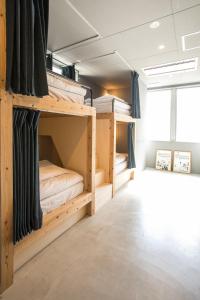 two bunk beds in a room with a window at Hostel STAND BY ME in Fukuoka