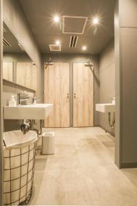 uma casa de banho com 2 lavatórios e um chuveiro em Hostel STAND BY ME em Fukuoka