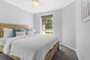 biała sypialnia z łóżkiem i oknem w obiekcie Waterford House w mieście North Creek