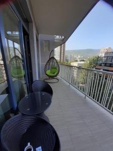 a balcony with chairs and tables on a building at m2 Tbilisi Central Park Apartment in Tbilisi City