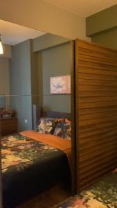 a bedroom with a bed and a large wooden closet at m2 Tbilisi Central Park Apartment in Tbilisi City