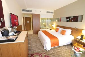 a hotel room with a bed and a desk at Centara Grand at Central Plaza Ladprao Bangkok in Bangkok