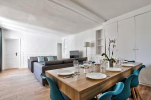 salon ze stołem i kanapą w obiekcie Appartement Quartier Le Marais 1 Free Netflix w Paryżu