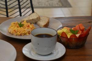 een tafel met een bord eten en een kopje koffie bij Hostal Magdalena in Santa Marta