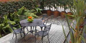 a table and chairs with a vase of flowers on it at Prisma Suites Chico 94 in Bogotá