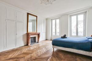 a white room with a bed and a fireplace at Appartement Quartier Le Marais 2 in Paris