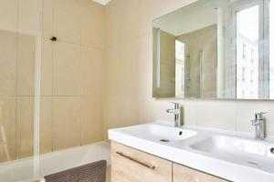 ein Bad mit einem Waschbecken und einem Spiegel in der Unterkunft Appartement Quartier Le Marais 2 in Paris