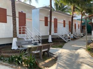 a bench in front of a building with palm trees at Khách sạn Ngọc Bích 2 in Thôn Tân Hội