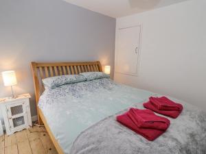a bedroom with a bed with red towels on it at Melbourne House in Aberaeron
