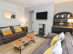 a living room with a couch and a fire place at Melbourne House in Aberaeron