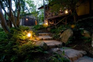a garden with stairs leading to a house at night at Arimasansoh Goshobessho in Kobe