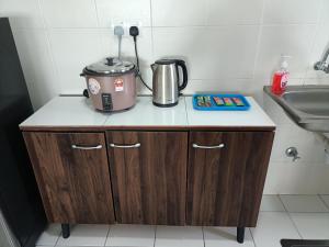 a appliance sitting on top of a counter next to a sink at Jannah Homestay Seruling in Putrajaya