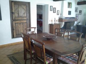 een eetkamer met een houten tafel en stoelen bij Maison d'hôtes Brameloup Jardin Ovale in Coudures