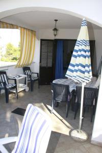 a patio with a table and a beach umbrella at Apartments Frano in Mirce