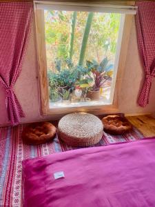 una camera con finestra, letto e tavolo di Hoàng Gia Trang a Da Lat