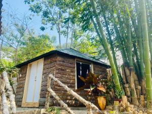 una pequeña cabaña de madera en medio de árboles en Hoàng Gia Trang en Dalat