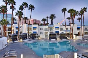 a large pool with palm trees and buildings at Las Vegas Serene Hotel in Las Vegas +45 photos