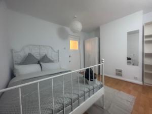 a white bedroom with a bed and a hallway at Holybush Bethnal Green in London