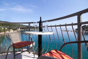 a table with wine glasses on a balcony with the water at Rooms Royal in Stomorska