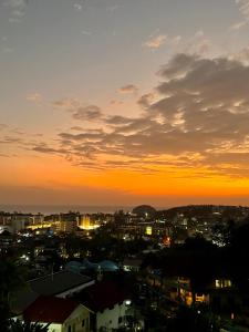 Blick auf eine Stadt bei Sonnenuntergang in der Unterkunft Mountain Seaview Luxury Apartments in Kata Beach