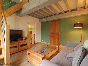 ein Wohnzimmer mit einem Sofa und einem TV in der Unterkunft Gîte Aunou-sur-Orne, 3 pièces, 6 personnes - FR-1-497-150 in Aunou-sur-Orne
