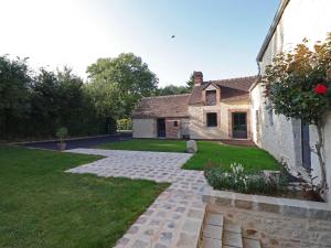 einen Garten mit einem Steingang neben einem Haus in der Unterkunft Gîte Aunou-sur-Orne, 3 pièces, 6 personnes - FR-1-497-150 in Aunou-sur-Orne