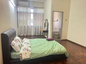 Un dormitorio con una cama con sábanas verdes y una ventana en Batu Pahat Airbnb Homestay Empire 15 en Batu Pahat
