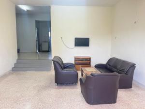 sala de estar con 2 sillas y TV en Batu Pahat Airbnb Homestay Empire 15 en Batu Pahat