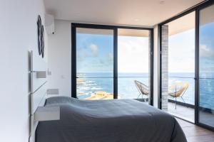 a bedroom with a bed and a view of the ocean at 3 bdr aprt, stunning seaview, rooftop pool - LCGR in Praia