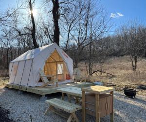 a tent with a picnic table and a bench at Tentrr Signature Site - Maramec Spring Park McDole's Meadow in Saint James