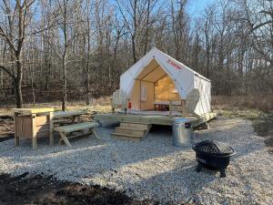 a tent with a picnic table and a grill at Tentrr Signature Site - Maramec Spring Park McDole's Meadow in Saint James