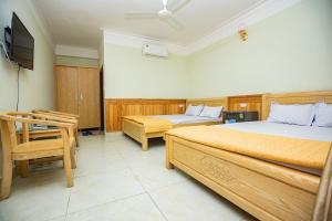 1 dormitorio con 2 camas, mesa y TV en Công Anh Hotel en Sầm Sơn