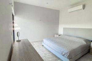 Dormitorio blanco con cama y mesa en Casa BV: Beautiful new house short walk from beach en Buenavista