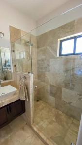 y baño con ducha, lavabo y espejo. en Casa BV: Beautiful new house short walk from beach en Buenavista