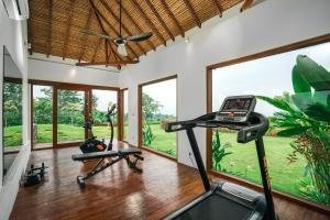 a gym with two exercise bikes in a room with windows at Villa Ravenala, Sumptuous 5BR Luxury Villa 10min away from Lovina in the North of Bali in Lovina